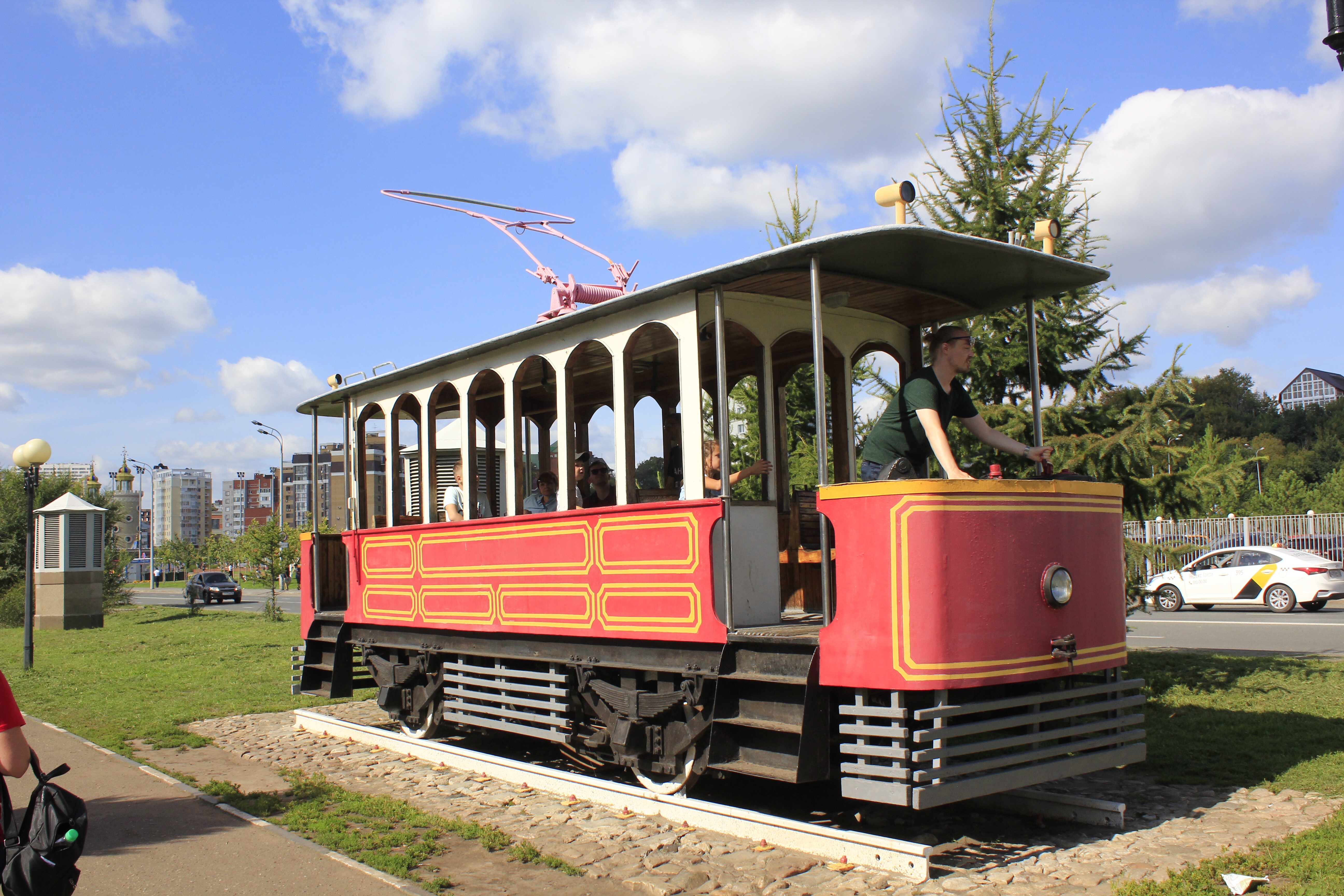 Jan steht auf dem offenen Podest einer historischen Straßenbahn und bedient das Schaltwerk